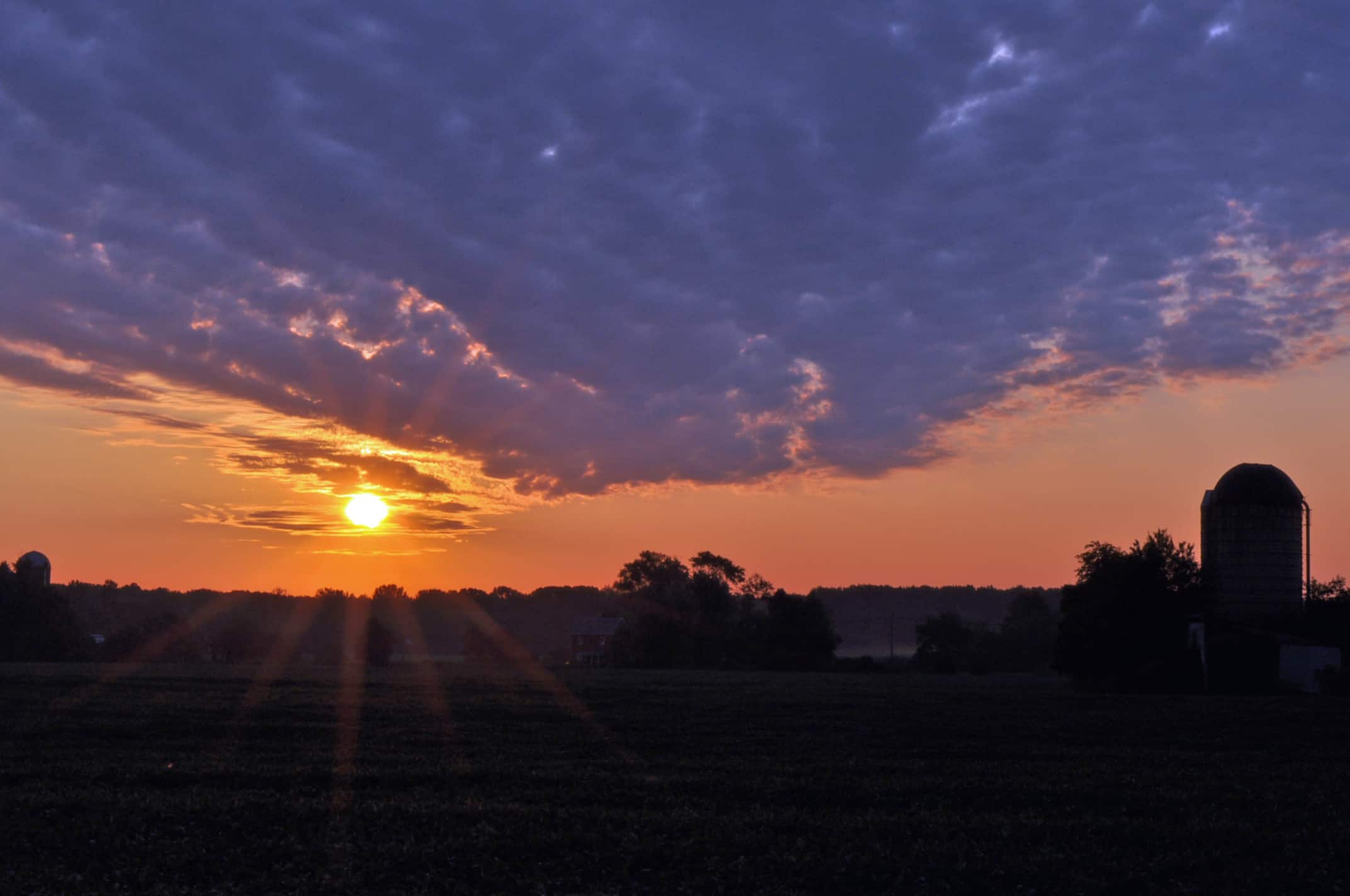 The sun rising over a Medford farm